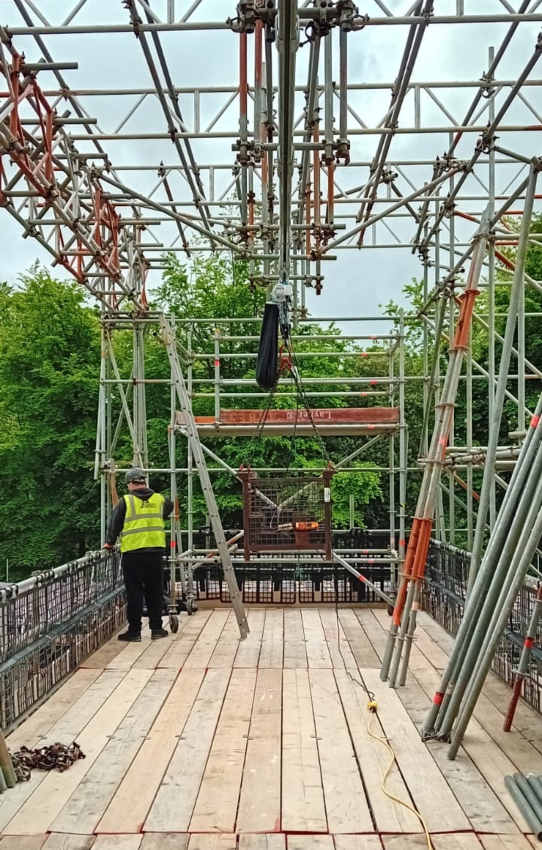 worker in high vis stood on roof scaffolding